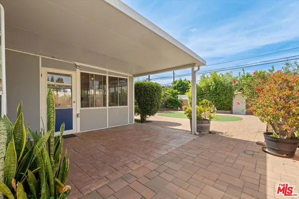 a view of a house with a yard and potted plants