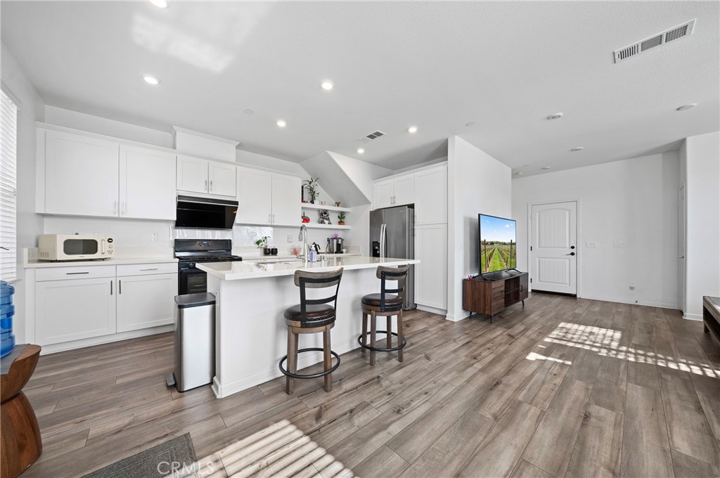 981 West Clover Avenue Rialto, CA 92376 - Photo 2 of 11 a open kitchen with white cabinets and stainless steel appliances
