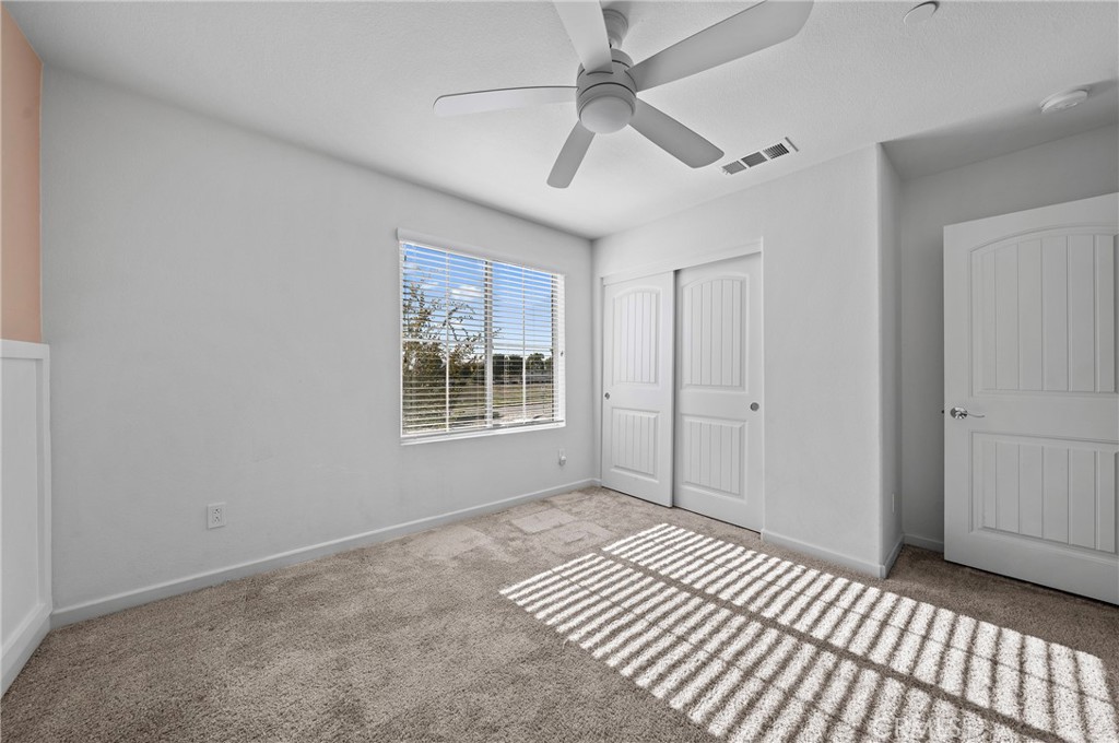 981 West Clover Avenue Rialto, CA 92376 - Photo 7 of 11 a view of a room with wooden floor ceiling fan and windows