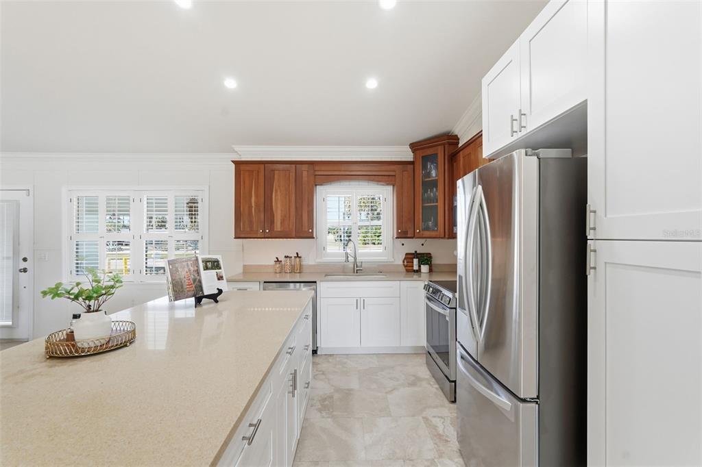 15302 Harbor Drive Madeira Beach, FL 33708 - Photo 15 of 47 a kitchen with stainless steel appliances a refrigerator a sink a stove and white cabinets