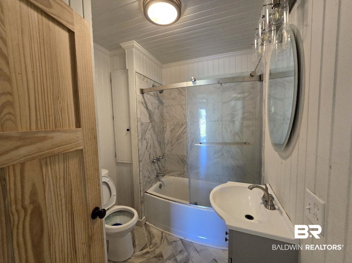 6464 Ridge Road Brewton, AL 36426 - Photo 10 of 14 Full bathroom featuring combined bath / shower with glass door, vanity, wooden walls, and crown molding