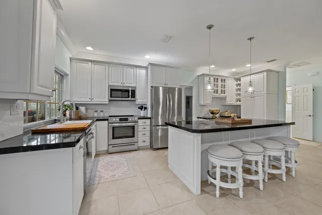 a kitchen with stainless steel appliances granite countertop a stove a sink and a refrigerator