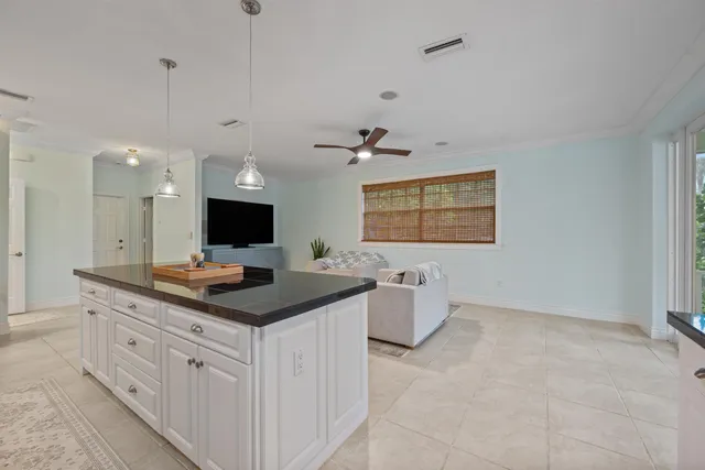a kitchen with granite countertop a stove and white cabinets