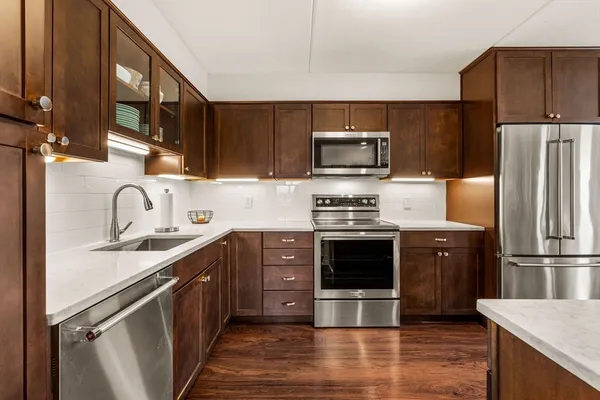 a kitchen with stainless steel appliances granite countertop a refrigerator stove and sink