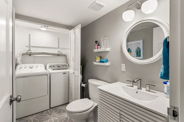 a bathroom with a sink mirror vanity and toilet