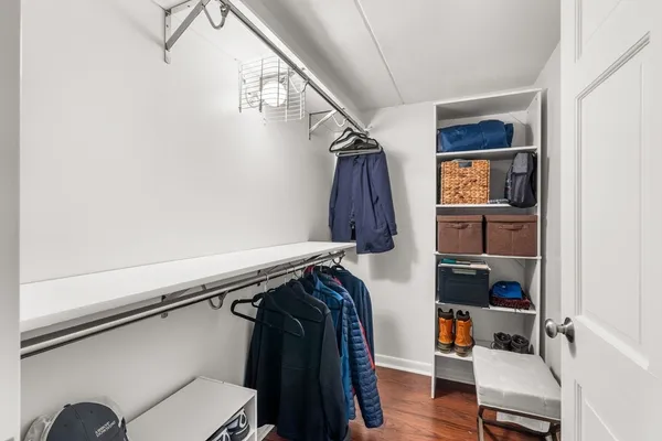 a view of walk in closet with clothes and shoes