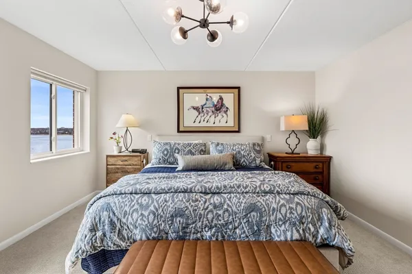 a bedroom with a large bed and a chandelier