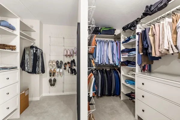 a view of walk in closet with clothes and shoes