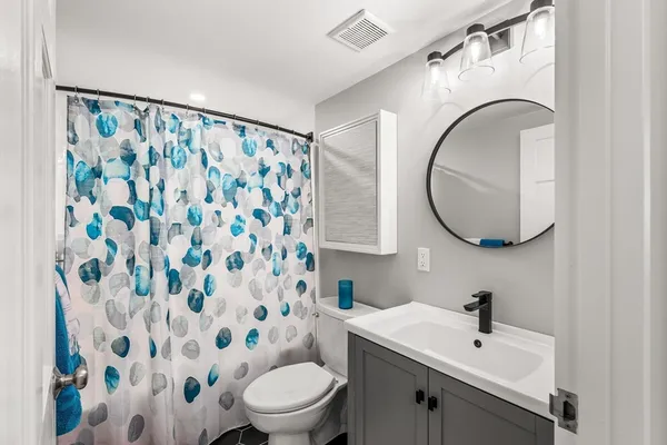 a bathroom with a sink mirror and a toilet