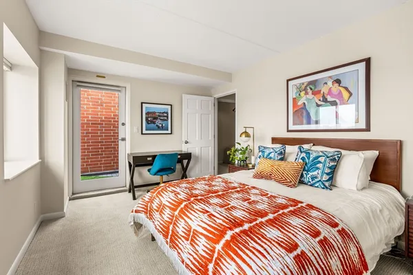 a bedroom with a bed and a painting on the wall