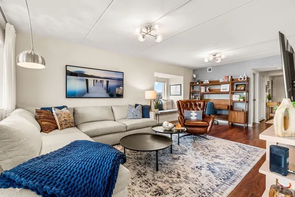 a living room with furniture a rug and a table