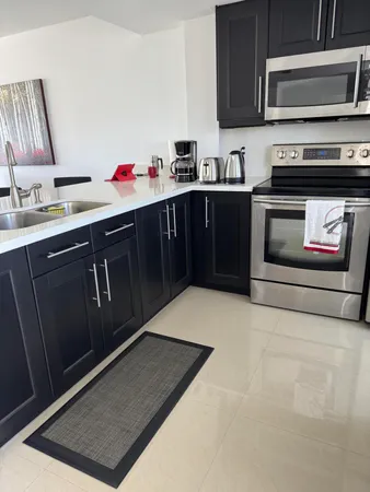 a kitchen with stainless steel appliances granite countertop a stove a sink and a microwave