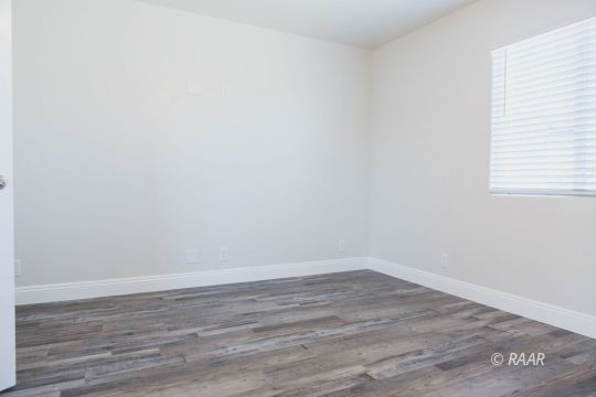 909 West Wasp Avenue Ridgecrest, CA 93555 - Photo 18 of 33 a view of an empty room with wooden floor and a window