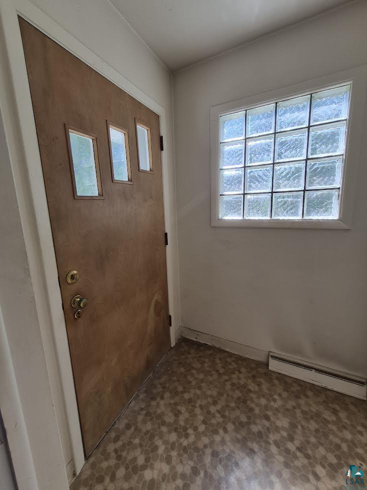 2109 West 22nd Street Duluth, MN 55811 - Photo 7 of 29 Entryway featuring patterned flooring, light wood-finish door with three rectangular lights, and a glass block window providing natural light. Large coat closet.