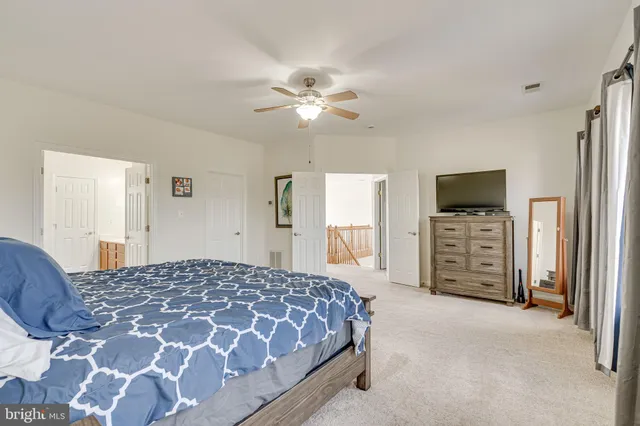 a bed sitting in a bedroom next to a window and a lamp