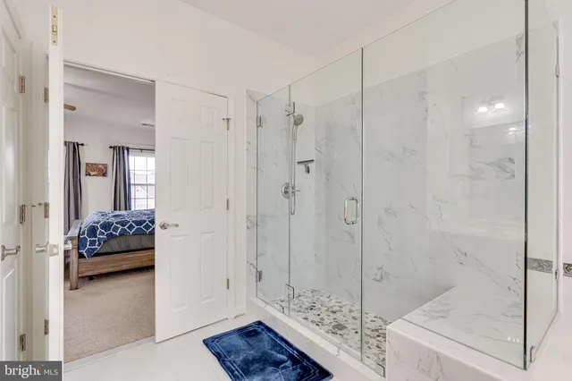 a bedroom with a bed a chair and a chandelier