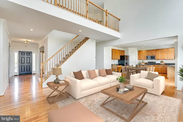 a living room with furniture hard wood floor and a table
