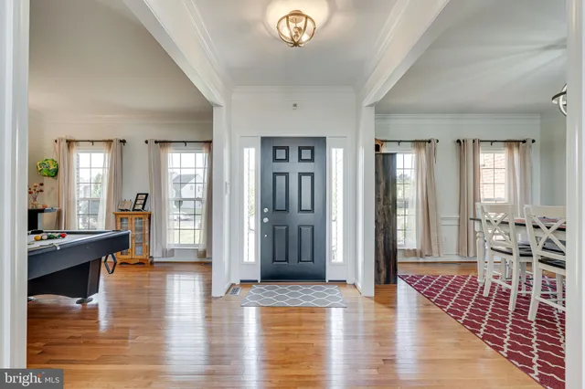 a view of a hallway with wooden floor and furniture