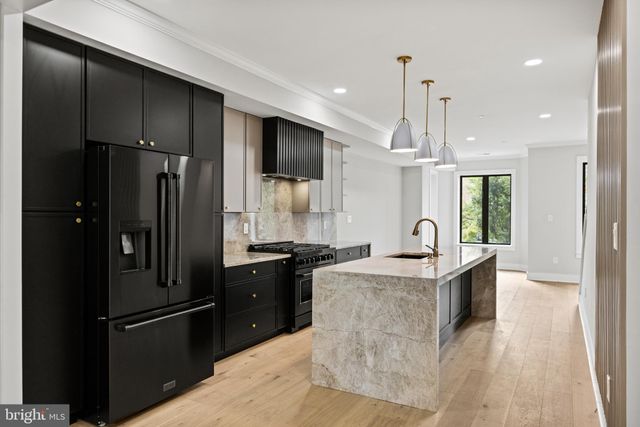 a kitchen with stainless steel appliances granite countertop a refrigerator and a sink