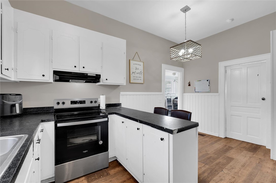 309 Hill Street Easley, SC 29640 - Photo 13 of 25 This bright kitchen features white cabinetry, dark countertops, and modern stainless steel appliances.