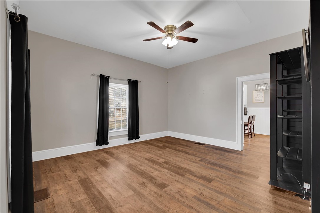 309 Hill Street Easley, SC 29640 - Photo 5 of 25 This bright room features durable laminate flooring and a ceiling fan, offering comfortable living space.