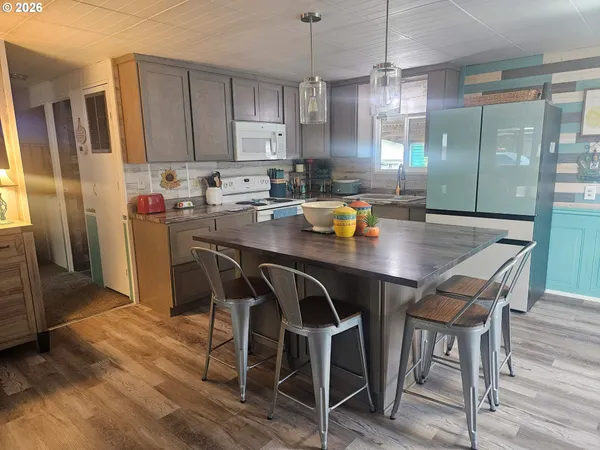 a kitchen with a table chairs refrigerator and cabinets