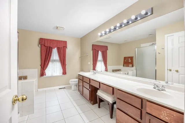 a bathroom with a tub sink and mirror