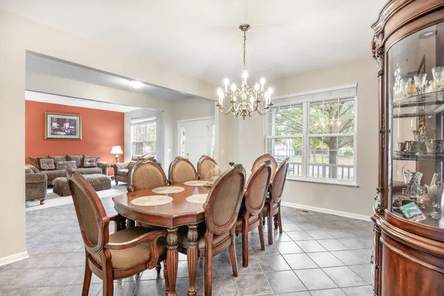 a view of a dining room and livingroom furniture a rug a chandelier and wooden floor