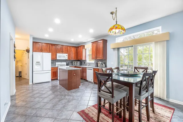 a dining room with a table chairs and a kitchen view