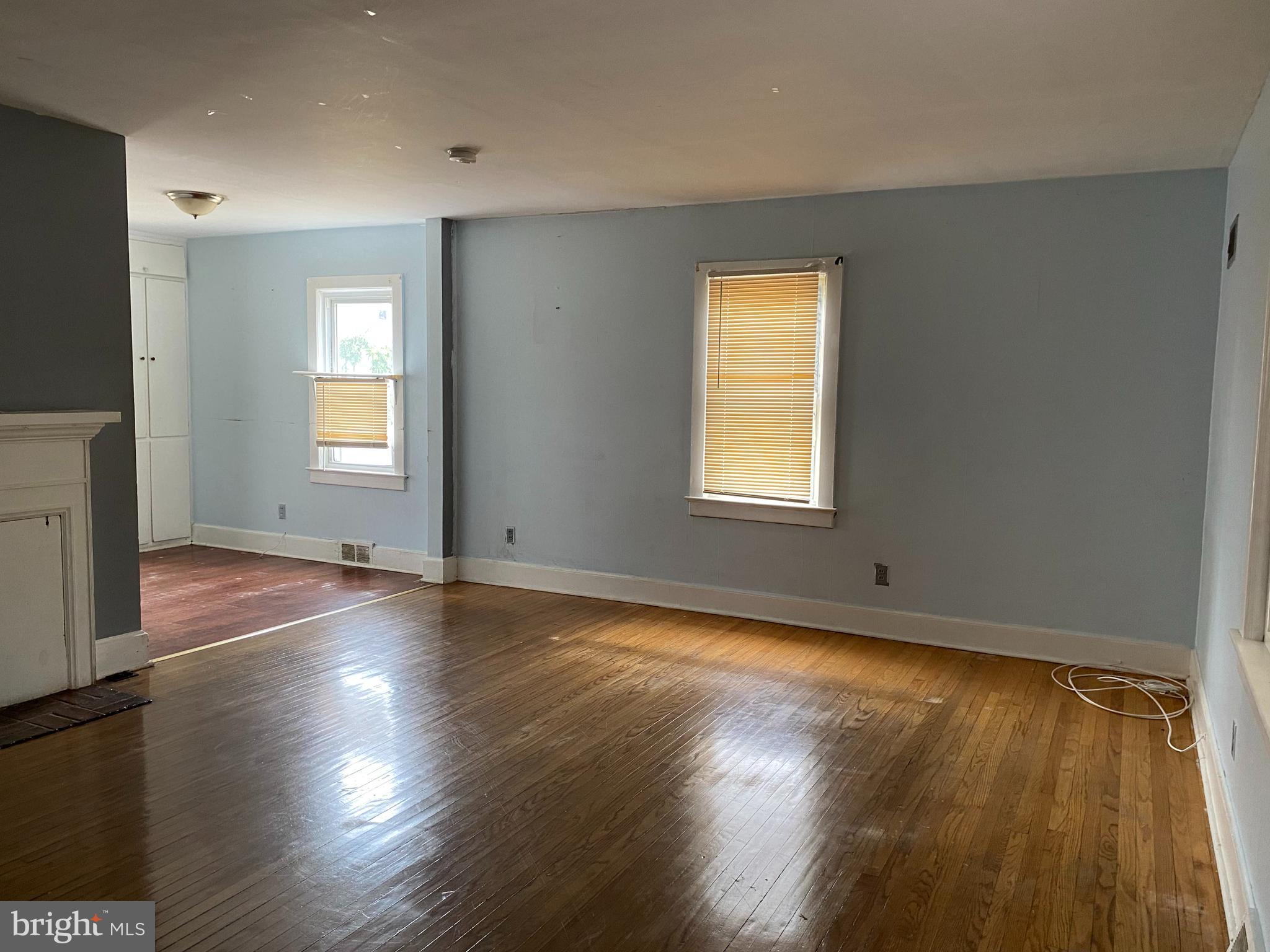 704 Bridgeboro Street Riverside, NJ 08075 - Photo 3 of 13 an empty room with wooden floor and windows