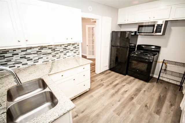 a kitchen with stainless steel appliances kitchen island a refrigerator sink and cabinets