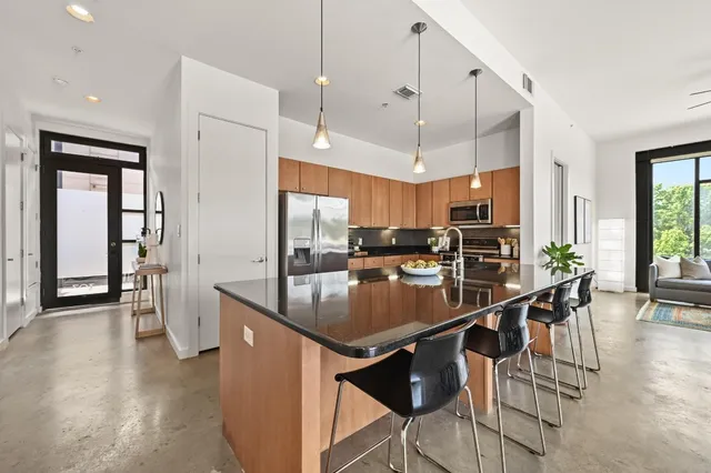 a kitchen with stainless steel appliances granite countertop a sink a stove and a refrigerator