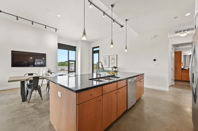 a kitchen with stainless steel appliances kitchen island a sink cabinets and wooden floor