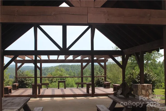 a view of backyard with lawn chairs and large trees