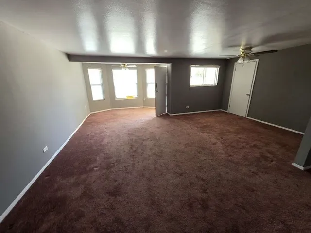 an empty room with windows and mirror