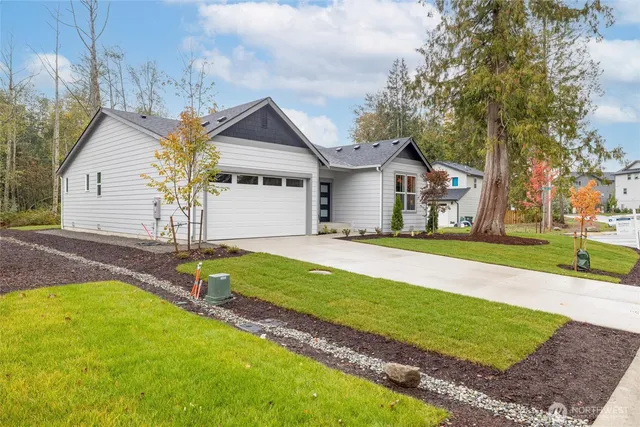 a view of a house with backyard and a tree
