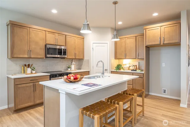 a kitchen with stainless steel appliances kitchen island granite countertop a sink and a stove