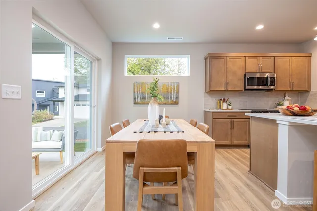 a kitchen with a stove a sink a dining table and chairs