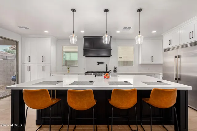 a kitchen with granite countertop a sink cabinets and stainless steel appliances