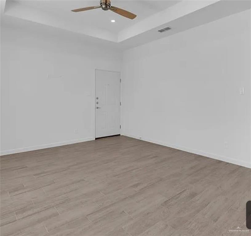 1312 Lore Drive, Unit 1 Weslaco, TX 78599 - Photo 6 of 10 Empty room with a tra. y ceiling, light wood-style flooring, recessed lighting, and ceiling fan