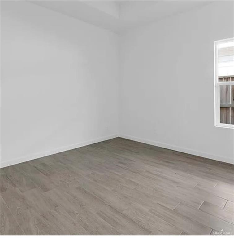 1312 Lore Drive, Unit 1 Weslaco, TX 78599 - Photo 7 of 10 Unfurnished room with wood finished floors and baseboards