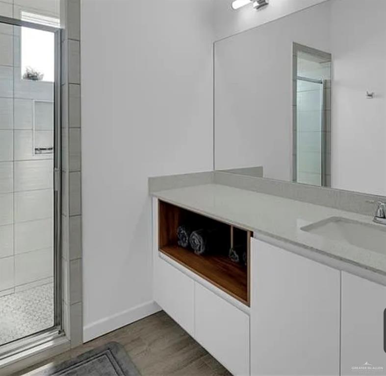 1312 Lore Drive, Unit 1 Weslaco, TX 78599 - Photo 8 of 10 Full bathroom with a stall shower, vanity, and light wood-style flooring