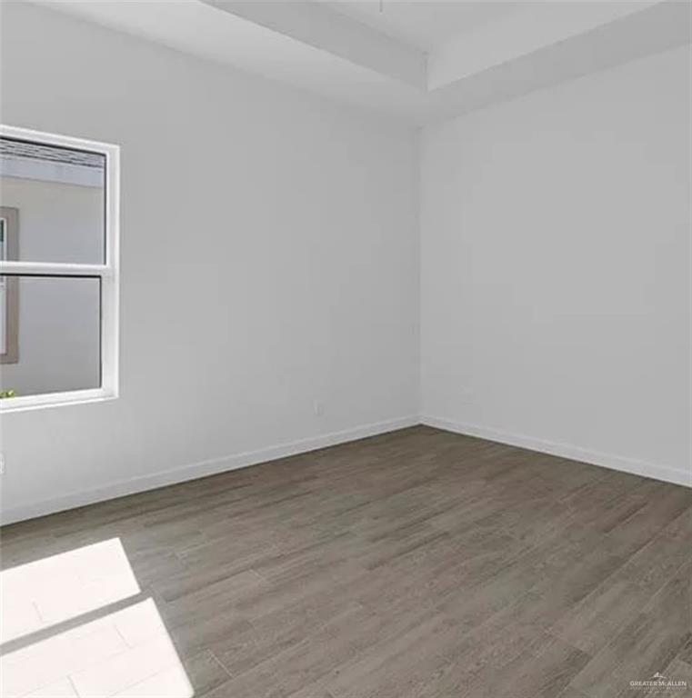 1312 Lore Drive, Unit 1 Weslaco, TX 78599 - Photo 9 of 10 Spare room featuring wood finished floors and a tray ceiling