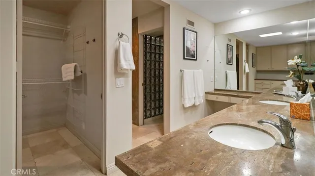a bathroom with a granite countertop sink a mirror and shower