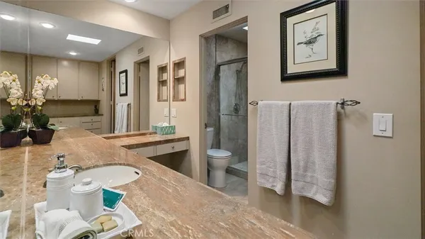 a spacious bathroom with a sink mirror vanity and toilet