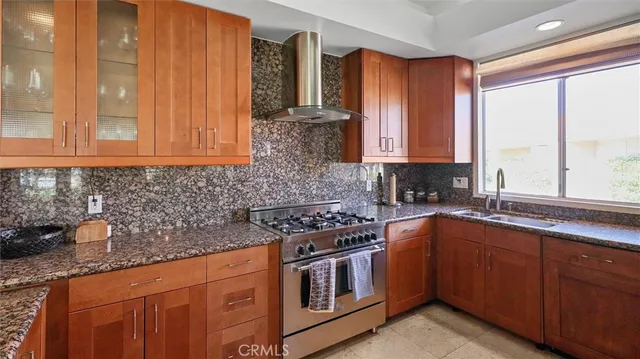 a kitchen with stainless steel appliances granite countertop a stove a sink and a microwave