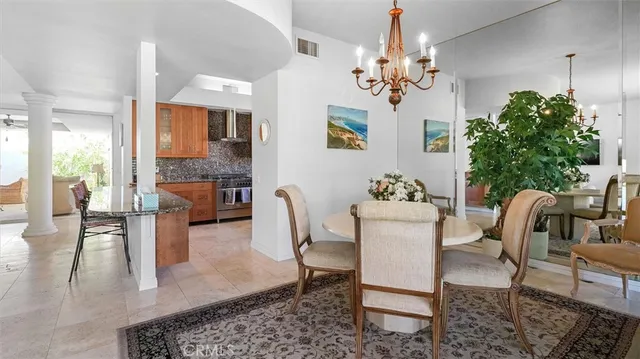 a dining room with furniture a chandelier and wooden floor