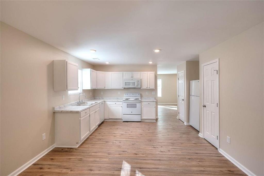 407 Wall Street Monroe, GA 30655 - Photo 12 of 51 a large kitchen with a lot of counter space and wooden floor