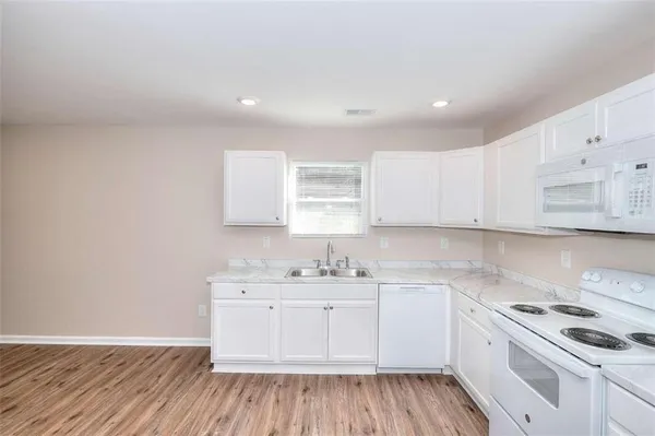 a kitchen with a sink stove and cabinets