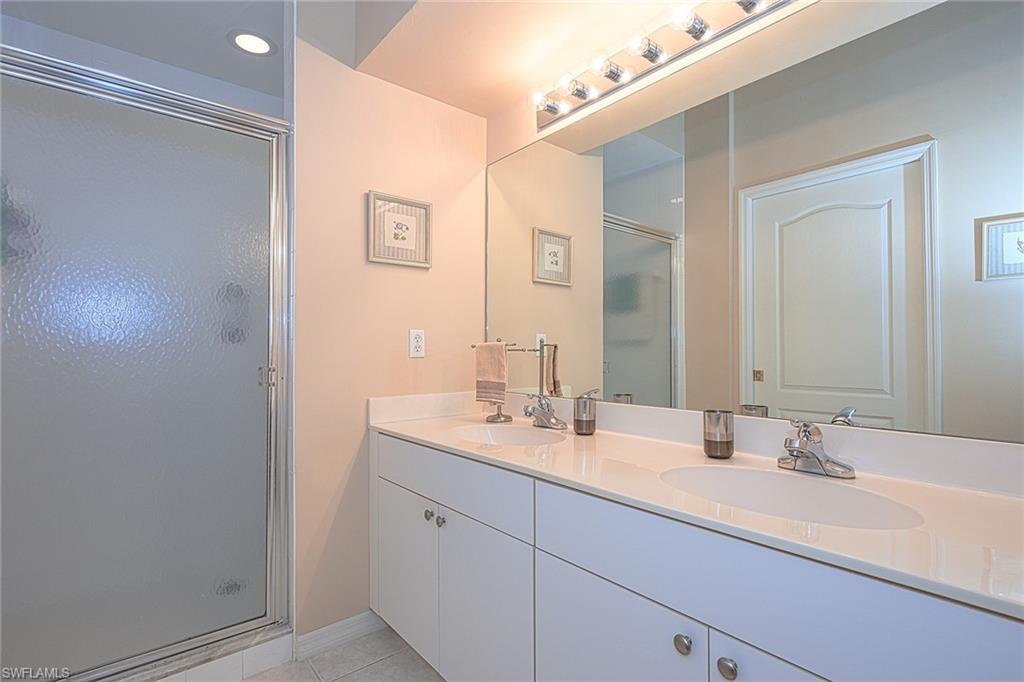 8640 Cedar Hammock Circle, Unit 523 Naples, FL 34112 - Photo 16 of 29 a bathroom with a double vanity sink and a mirror